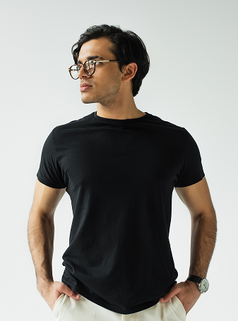 Stylish man in eyeglasses standing with hands in pockets